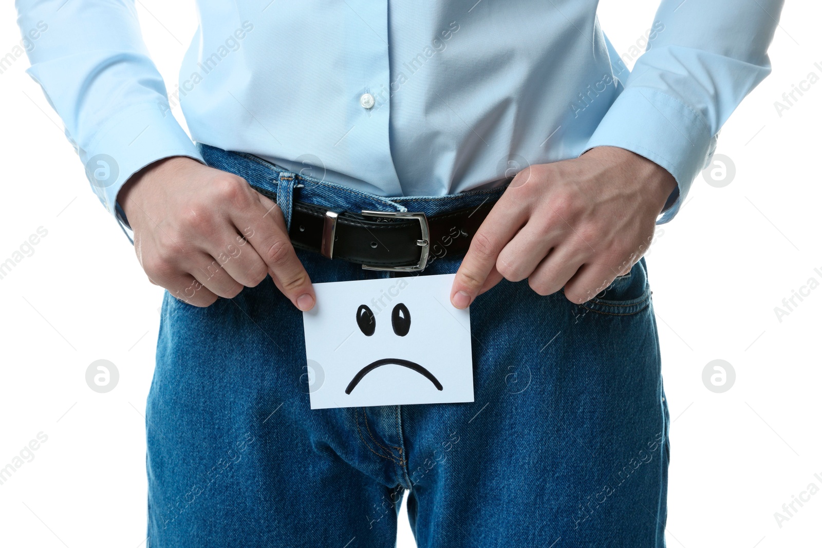 Photo of STD (sexually transmitted diseases). Man holding sticky note with drawn sad face on white background, closeup