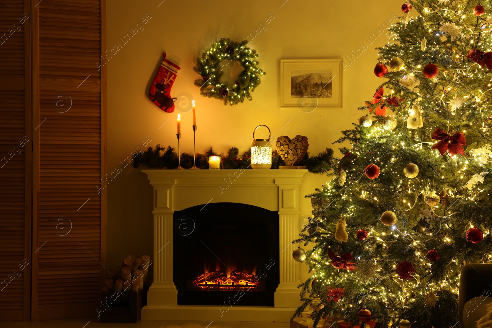 Photo of Decorated Christmas tree near fireplace in room. Festive interior design