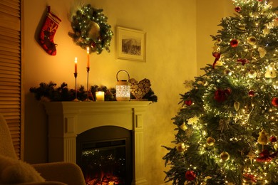 Decorated Christmas tree near fireplace in room. Festive interior design