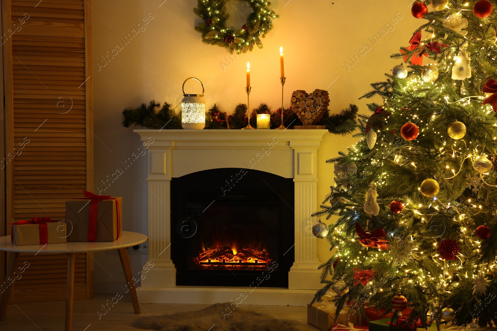 Photo of Decorated Christmas tree near fireplace in room. Festive interior design