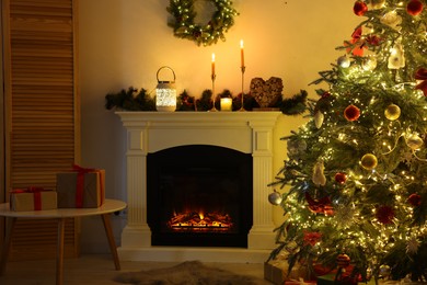 Photo of Decorated Christmas tree near fireplace in room. Festive interior design