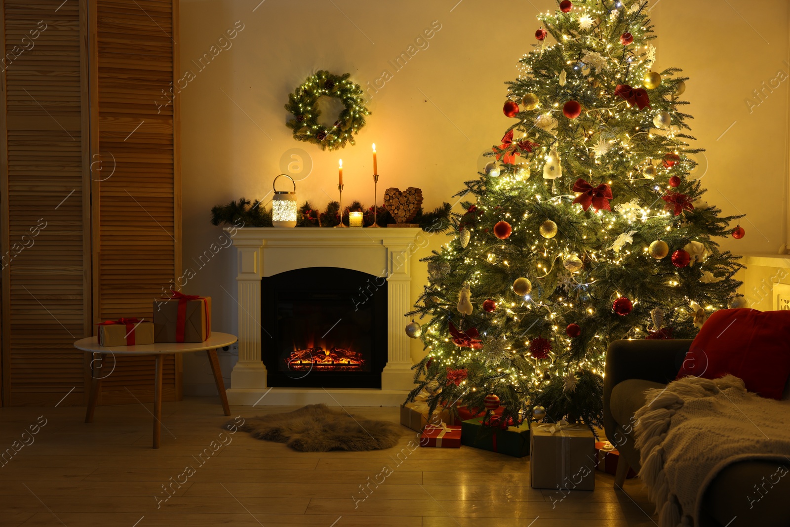 Photo of Decorated Christmas tree near fireplace in room. Festive interior design