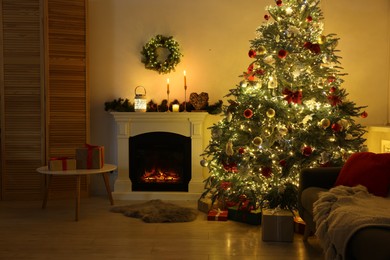 Decorated Christmas tree near fireplace in room. Festive interior design