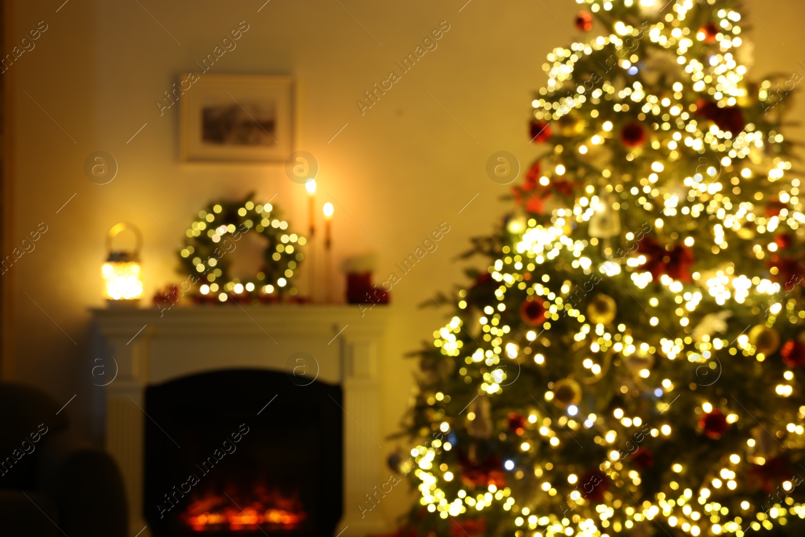 Photo of Blurred view of decorated Christmas tree near fireplace in room. Festive interior design