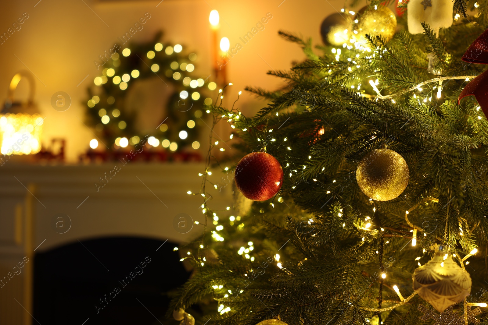 Photo of Decorated Christmas tree near fireplace in room, closeup. Festive interior design