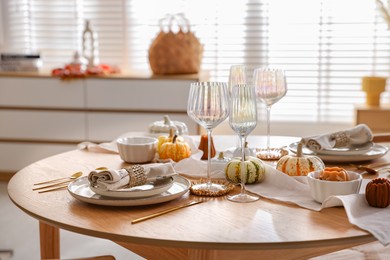 Stylish table setting with beautiful dishware and autumn decor in dining room