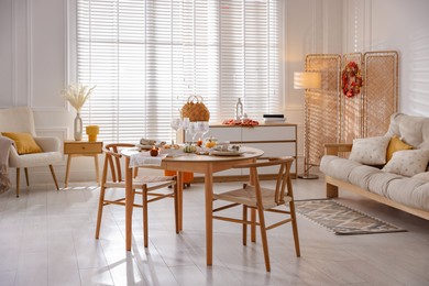 Photo of Stylish table setting with beautiful dishware and autumn decor in dining room