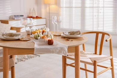 Stylish table setting with beautiful dishware and autumn decor in dining room