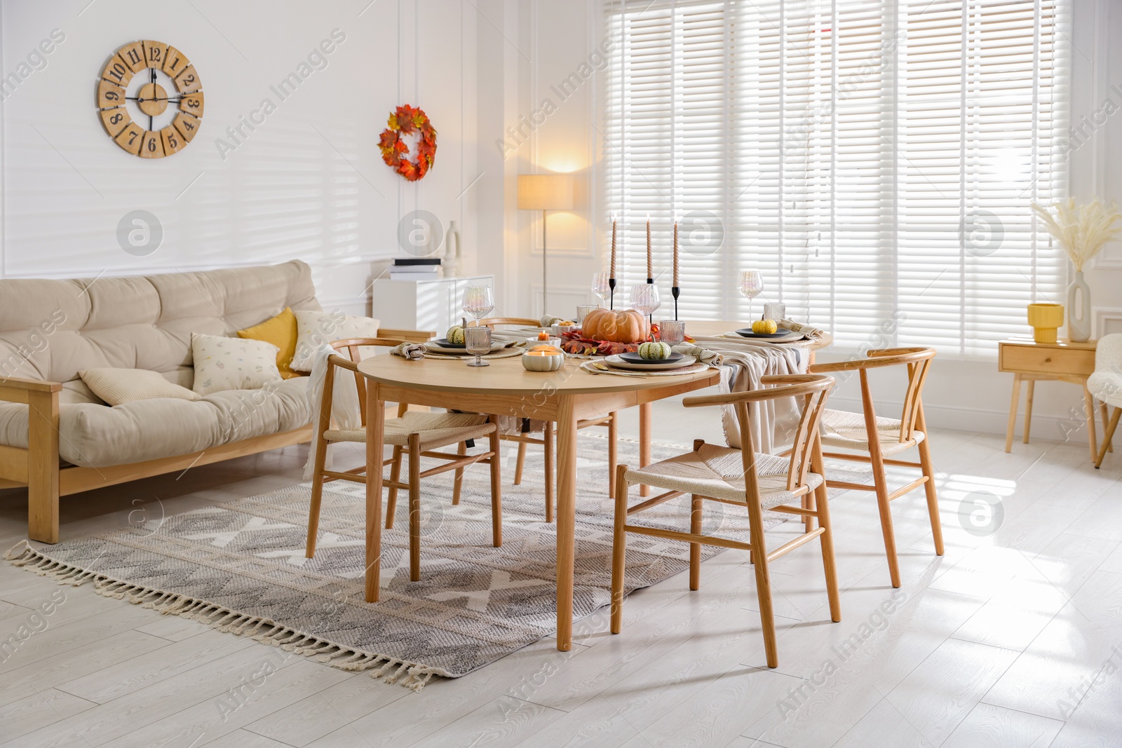 Photo of Stylish table setting with beautiful dishware and autumn decor in dining room