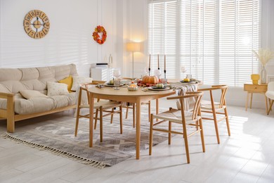 Stylish table setting with beautiful dishware and autumn decor in dining room