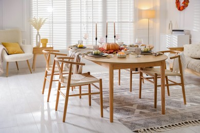 Photo of Stylish table setting with beautiful dishware and autumn decor in dining room