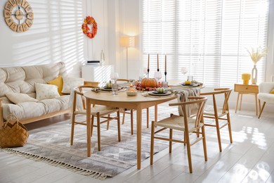 Photo of Stylish table setting with beautiful dishware and autumn decor in dining room