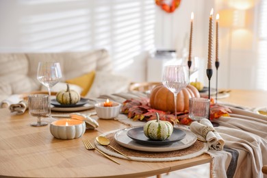 Stylish table setting with beautiful dishware and autumn decor in dining room