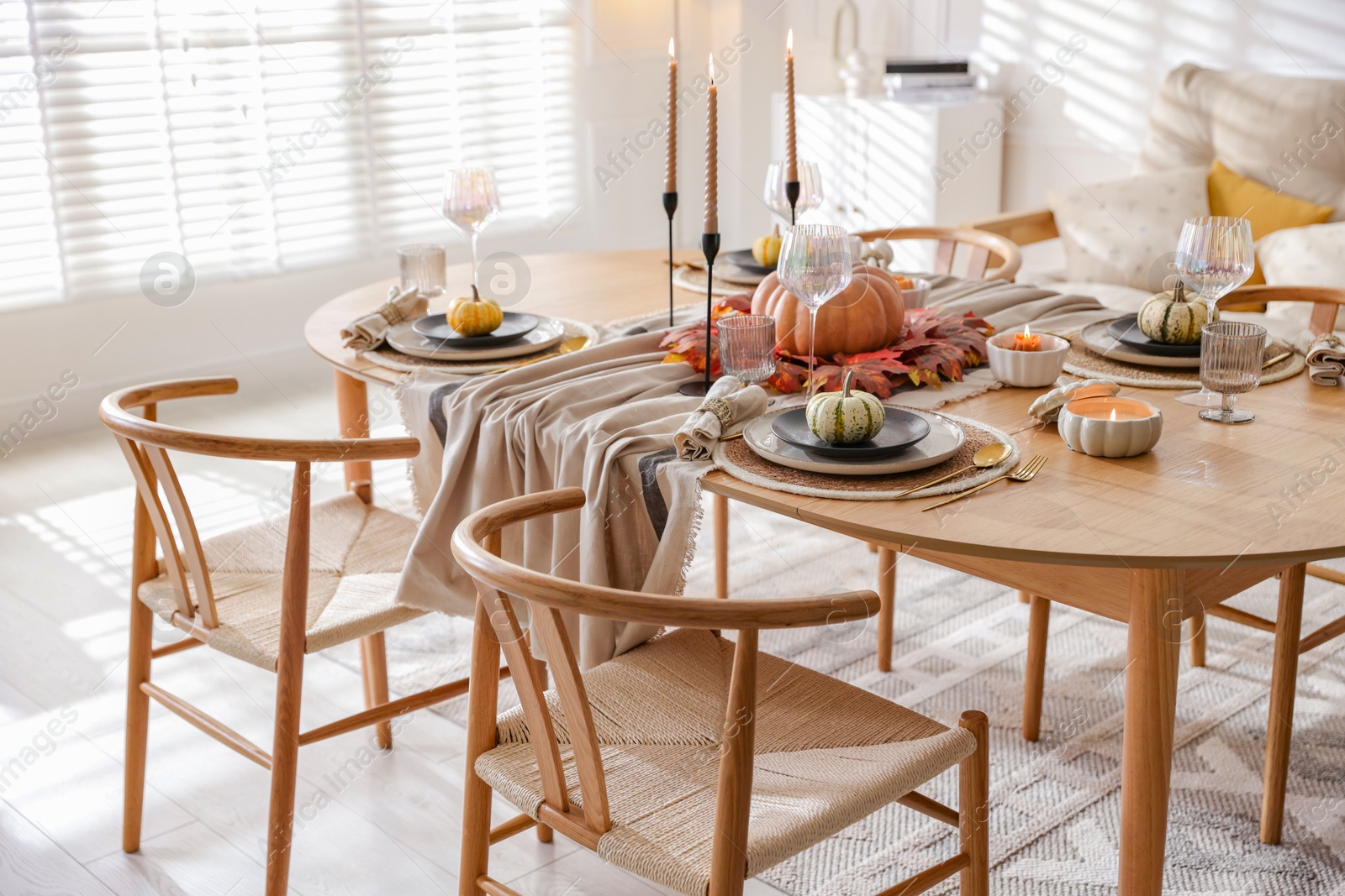 Photo of Stylish table setting with beautiful dishware and autumn decor in dining room