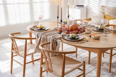 Photo of Stylish table setting with beautiful dishware and autumn decor in dining room