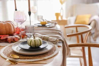 Stylish table setting with beautiful dishware and autumn decor in dining room