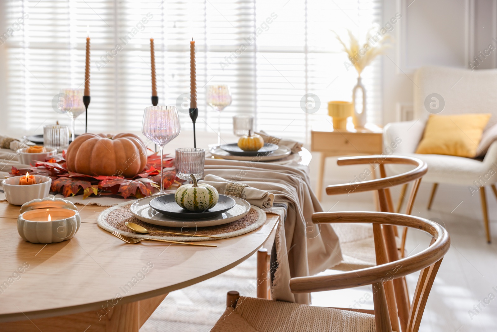 Photo of Stylish table setting with beautiful dishware and autumn decor in dining room