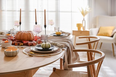 Stylish table setting with beautiful dishware and autumn decor in dining room