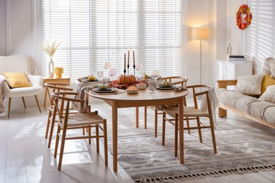 Photo of Stylish table setting with beautiful dishware and autumn decor in dining room