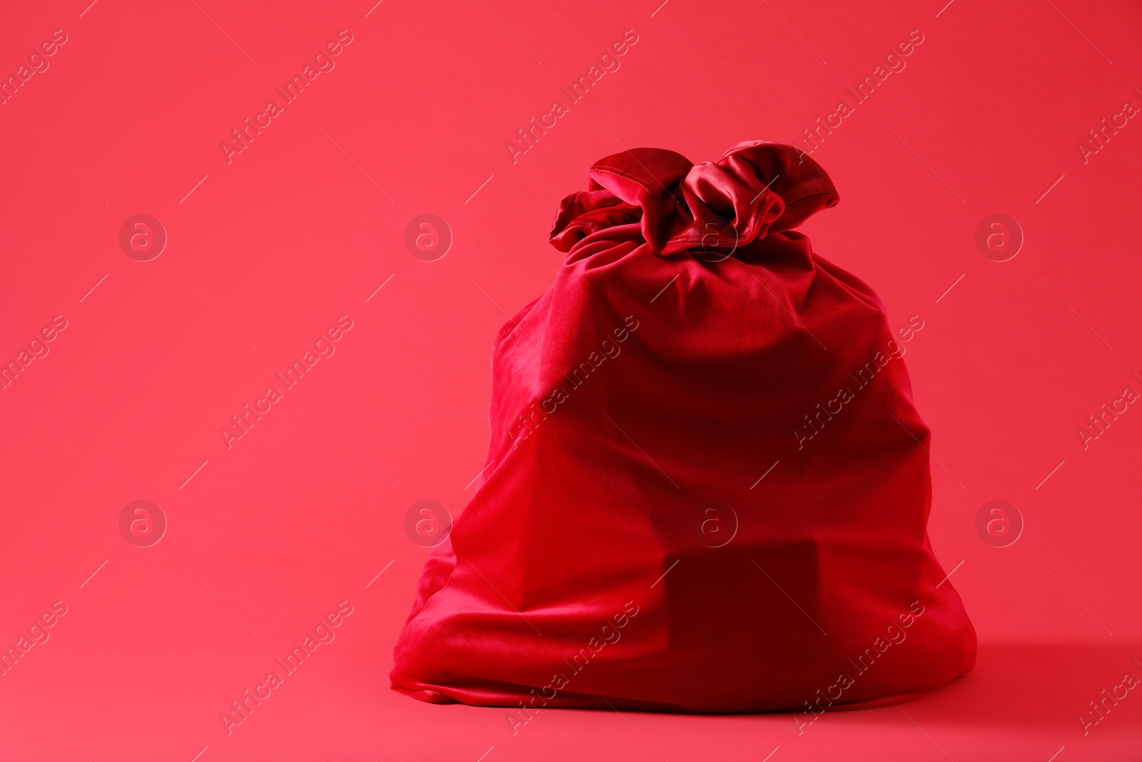 Photo of One Santa Claus bag on red background, space for text