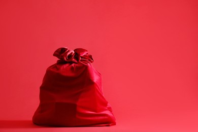 Photo of One Santa Claus bag on red background, space for text