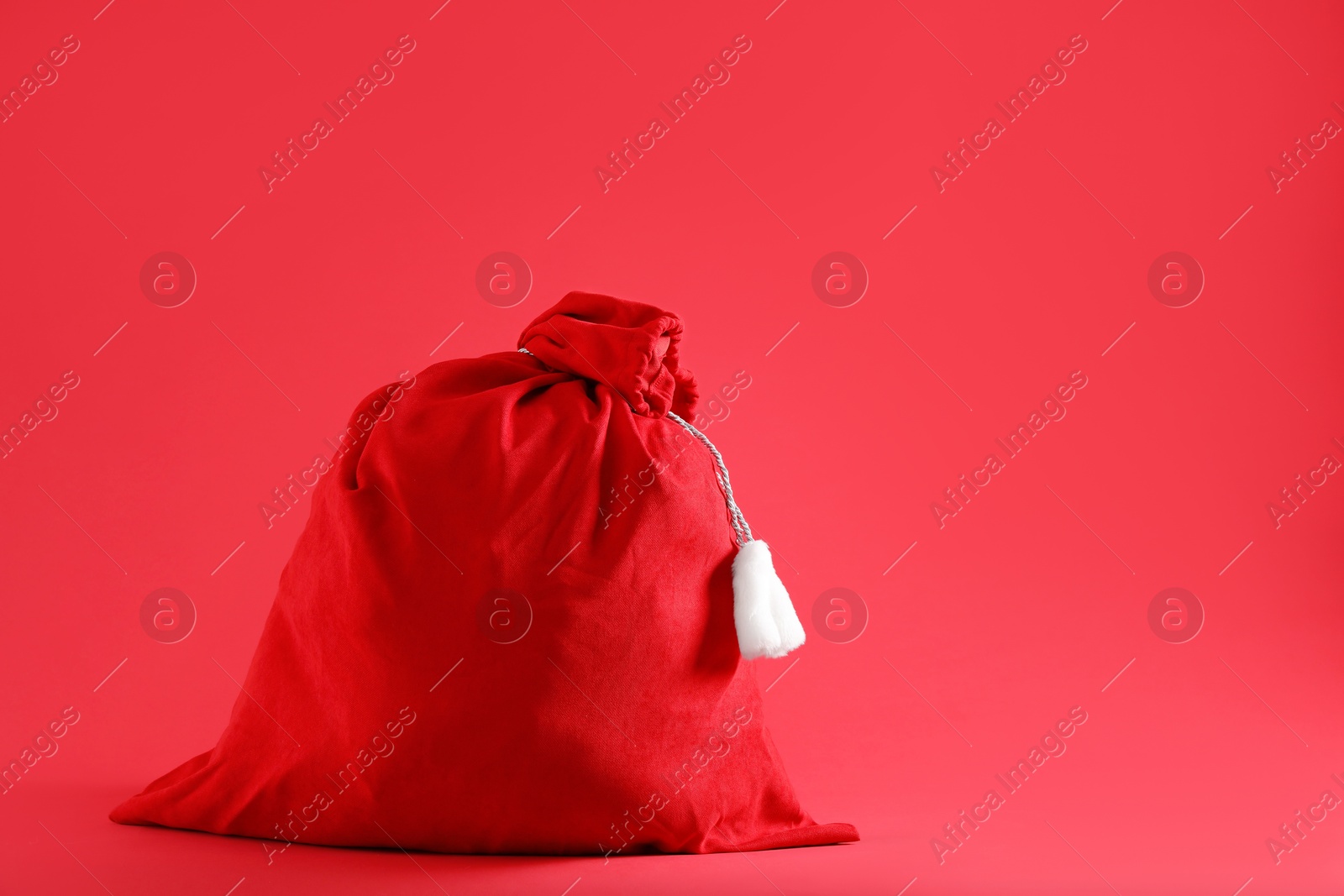 Photo of One Santa Claus bag on red background, space for text