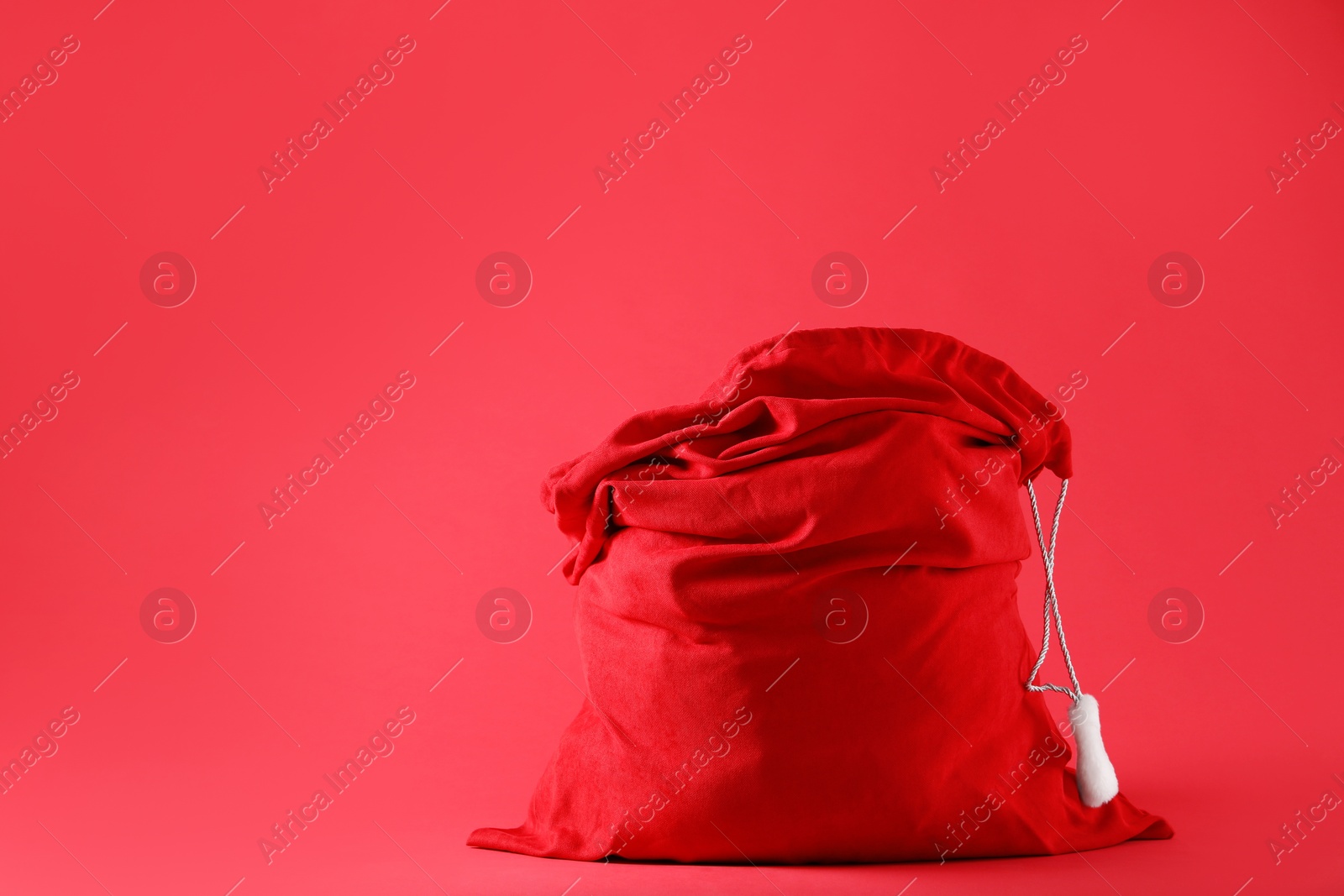 Photo of One Santa Claus bag on red background, space for text