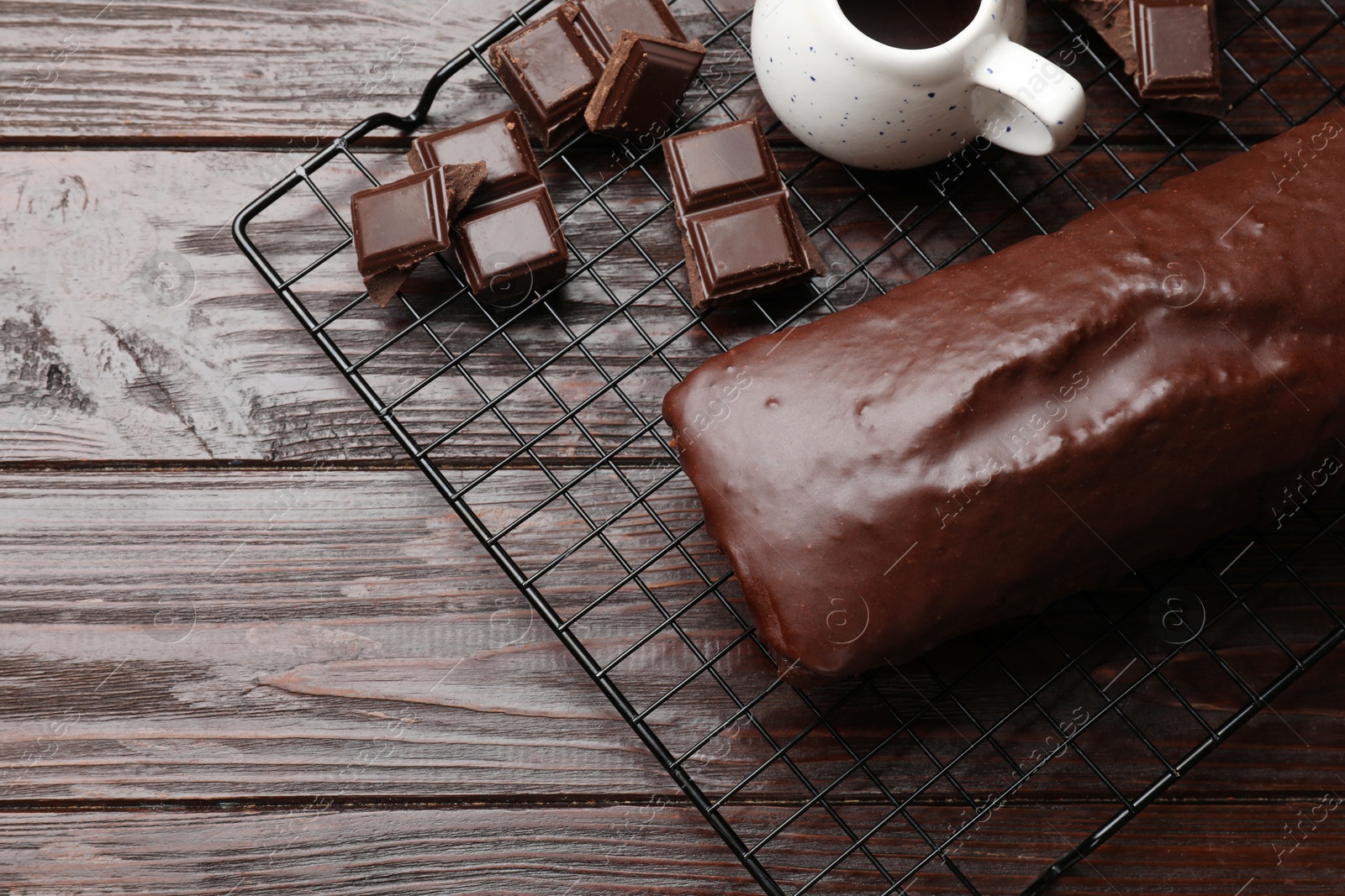 Photo of Tasty sponge cake and pieces of chocolate on wooden table, top view