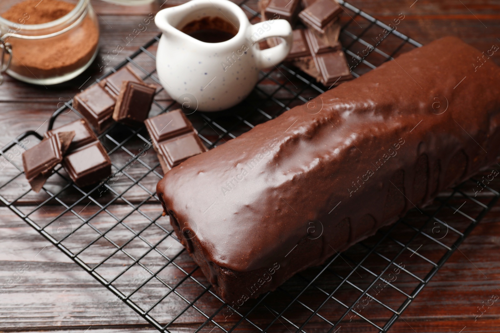 Photo of Tasty chocolate sponge cake and ingredients on wooden table, closeup