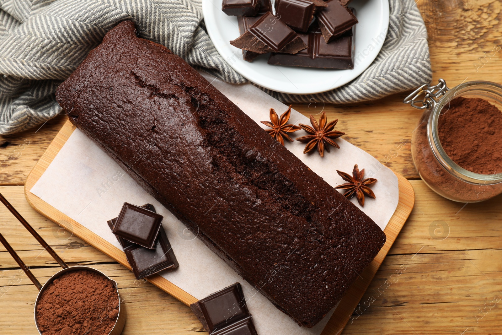 Photo of Tasty chocolate sponge cake and ingredients on wooden table, top view