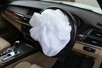 Photo of Opened airbag in automobile, closeup. Car safety equipment