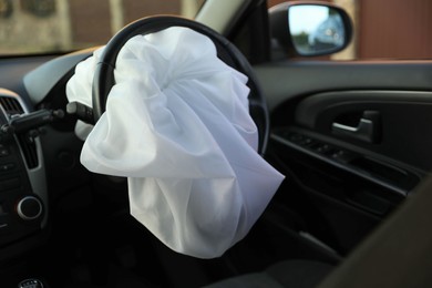 Photo of Opened airbag in automobile, closeup. Car safety equipment