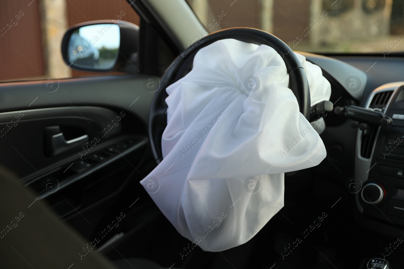 Photo of Opened airbag in automobile, closeup. Car safety equipment