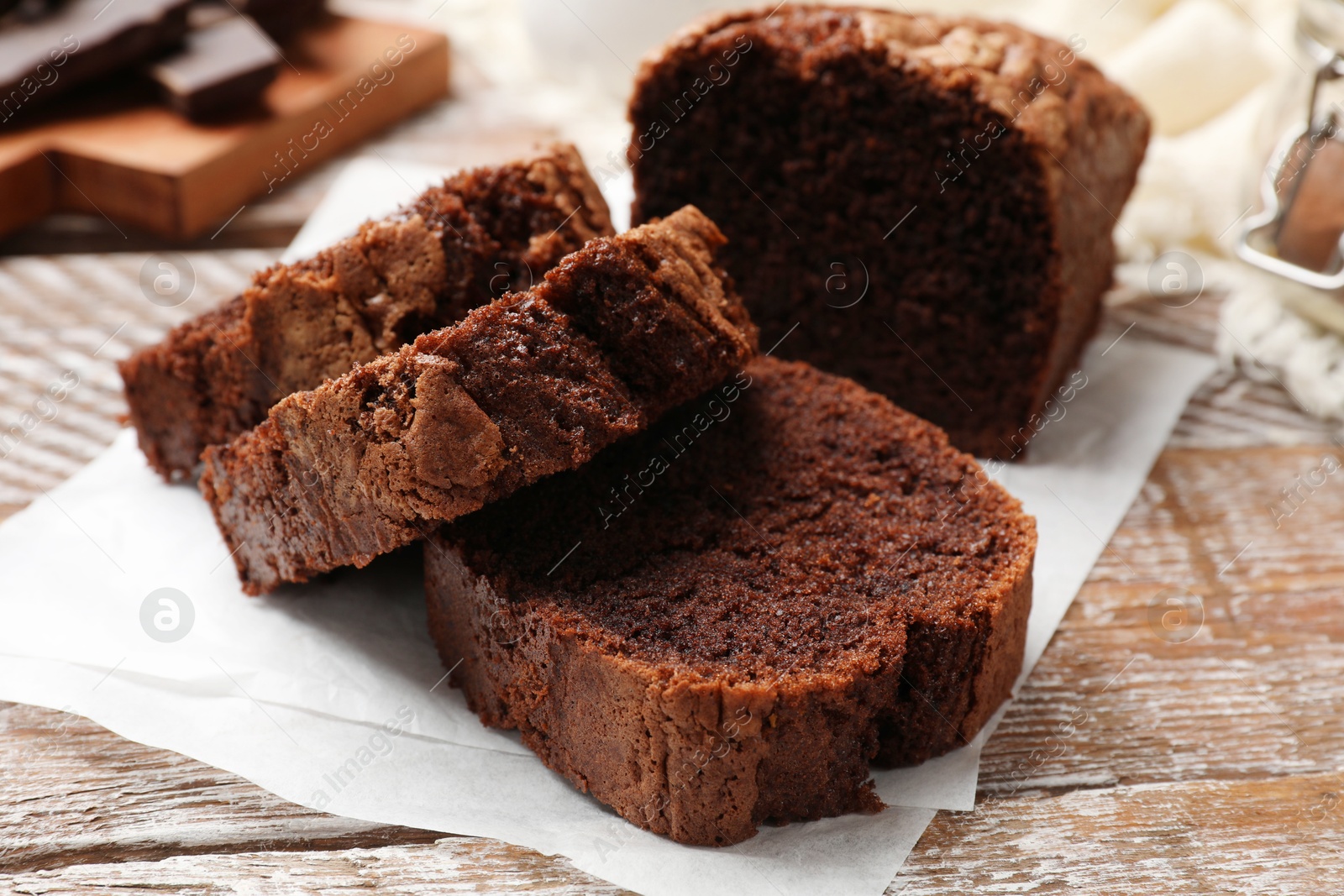 Photo of Delicious cut chocolate sponge cake on wooden table, closeup