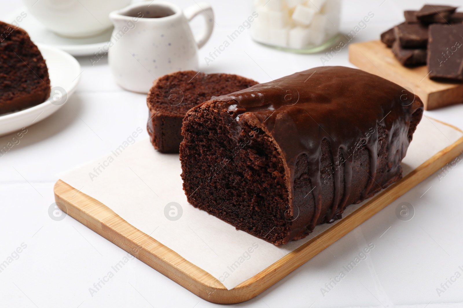 Photo of Delicious chocolate sponge cake on white tiled table