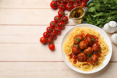 Delicious pasta with meatballs and ingredients on white wooden table, flat lay. Space for text