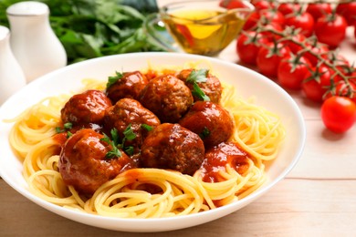 Photo of Delicious pasta with meatballs and ingredients on white wooden table, closeup