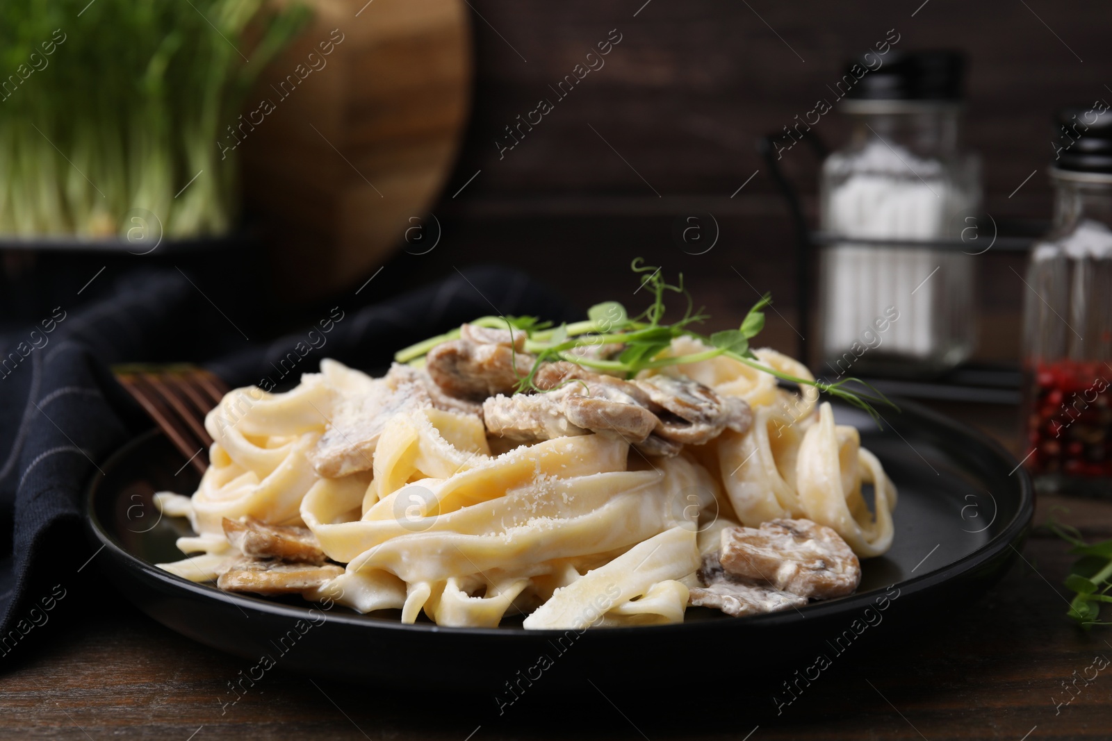 Photo of Delicious pasta with mushrooms on wooden table, closeup