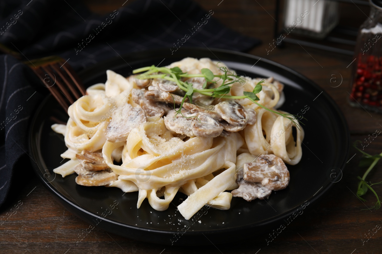 Photo of Delicious pasta with mushrooms on wooden table, closeup