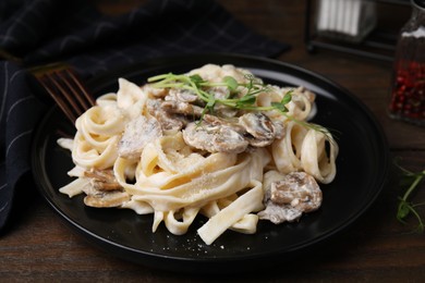 Photo of Delicious pasta with mushrooms on wooden table, closeup