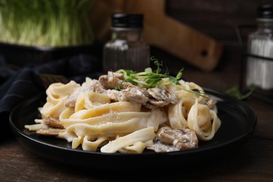 Photo of Delicious pasta with mushrooms on wooden table, closeup