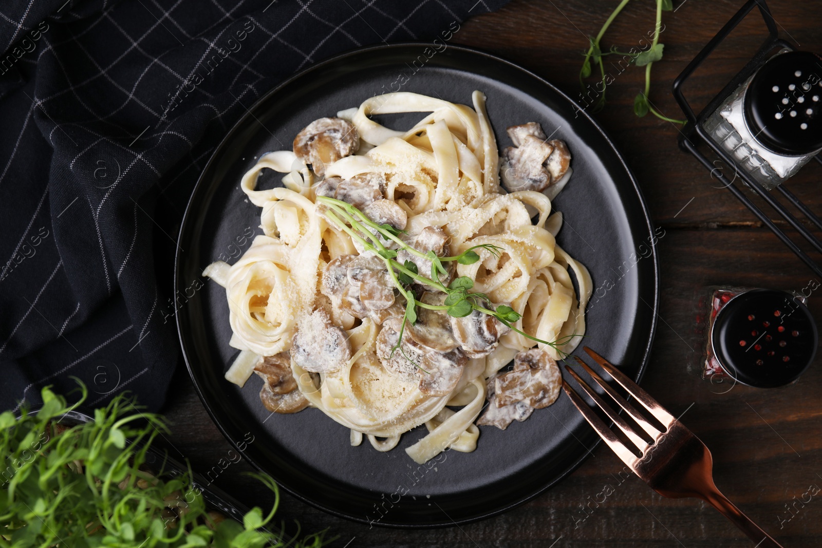 Photo of Delicious pasta with mushrooms served on wooden table, flat lay