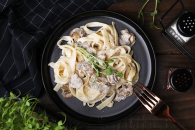 Photo of Delicious pasta with mushrooms served on wooden table, flat lay