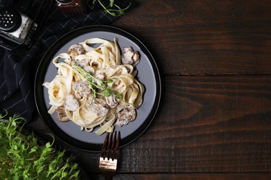 Photo of Delicious pasta with mushrooms served on wooden table, flat lay. Space for text