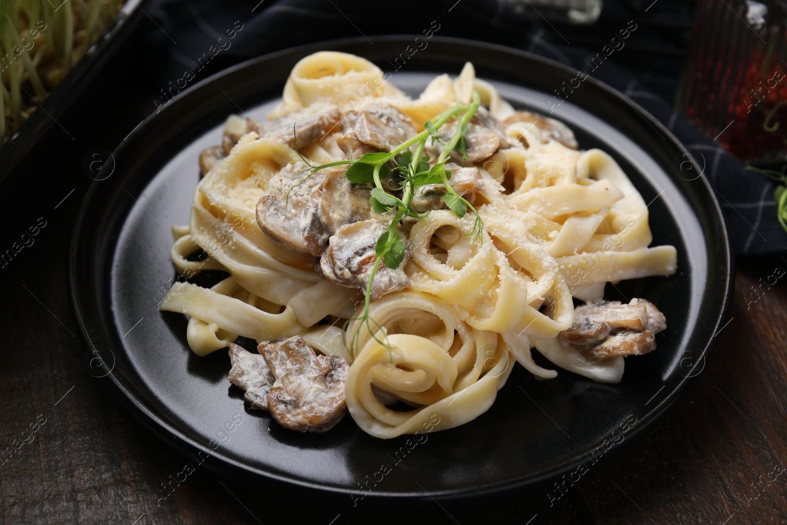 Photo of Delicious pasta with mushrooms on wooden table, closeup