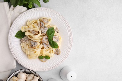 Photo of Delicious pasta with mushrooms and basil on light table, flat lay. Space for text