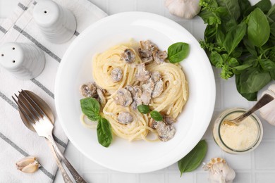 Photo of Delicious pasta with mushrooms and basil served on white tiled table, flat lay