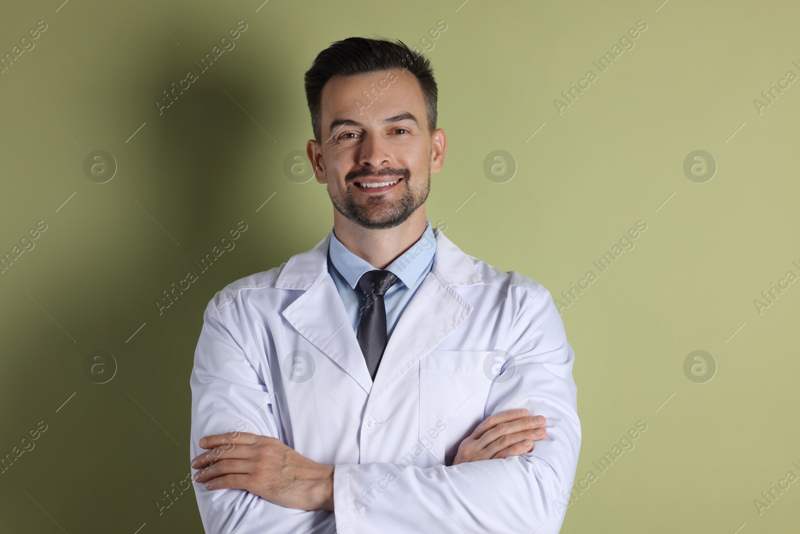 Photo of Portrait of smiling doctor on olive background