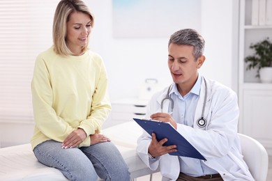 Healthcare worker with clipboard and patient in hospital