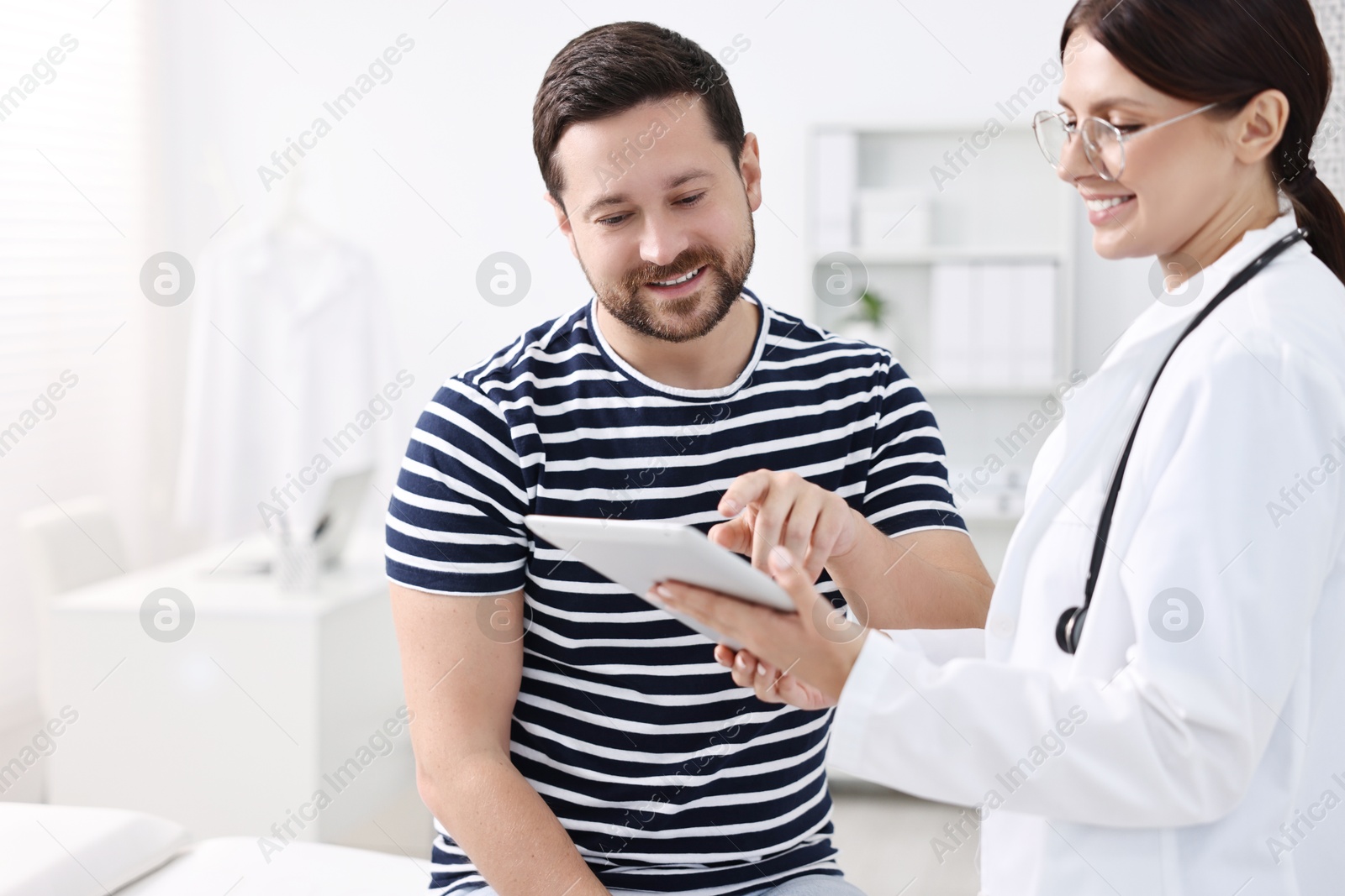 Photo of Healthcare worker with tablet and patient in hospital